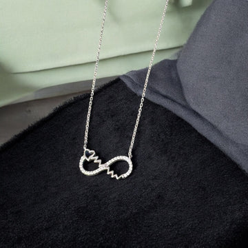 Silver necklace with a unique pendant on a black surface