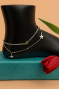 Silver double chain anklet with star and airplane charms on black mannequin