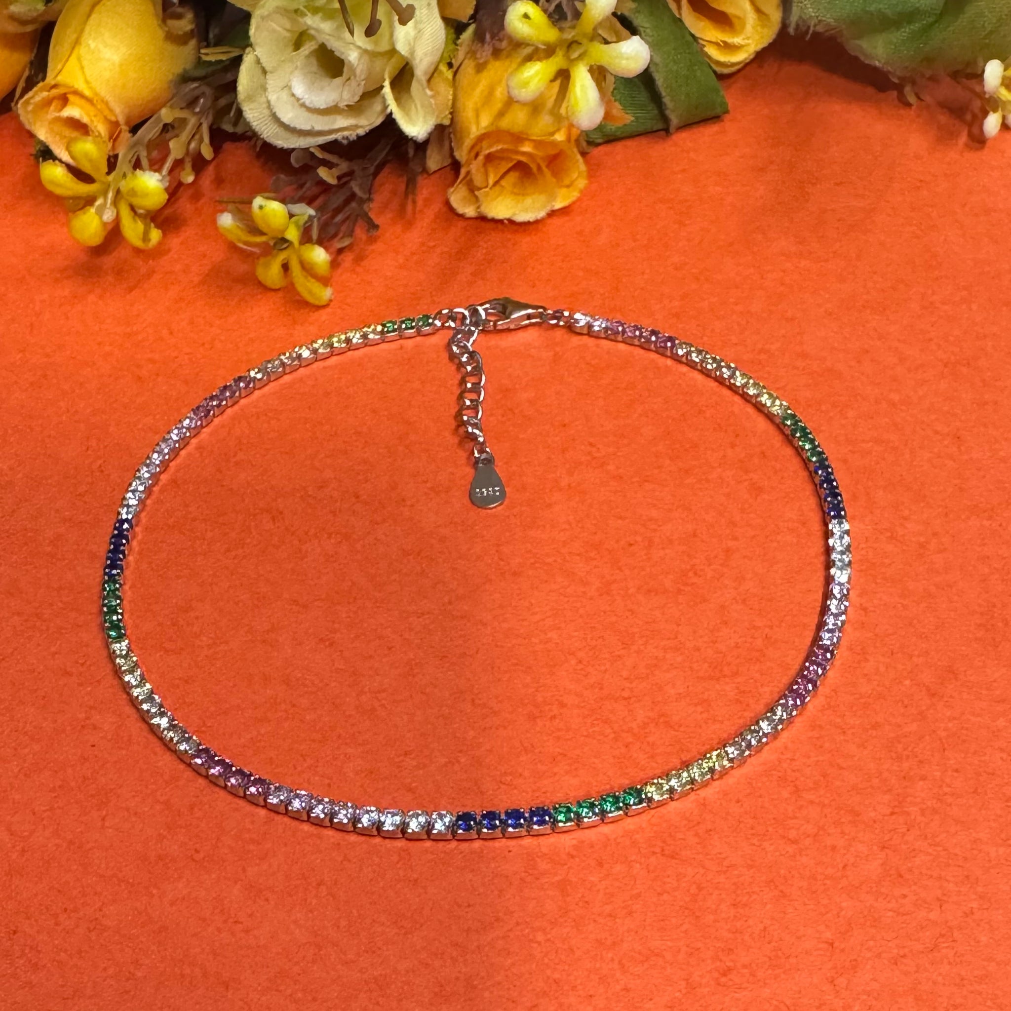 Multicolored beaded necklace on an orange background with flowers