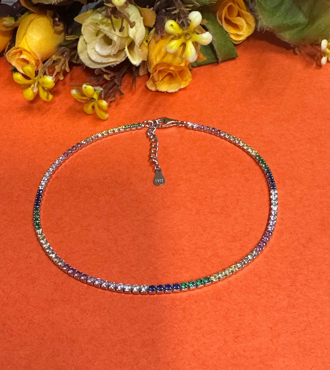 Multicolored beaded necklace on an orange background with flowers