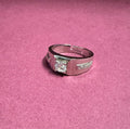 Silver ring with a diamond on a pink background