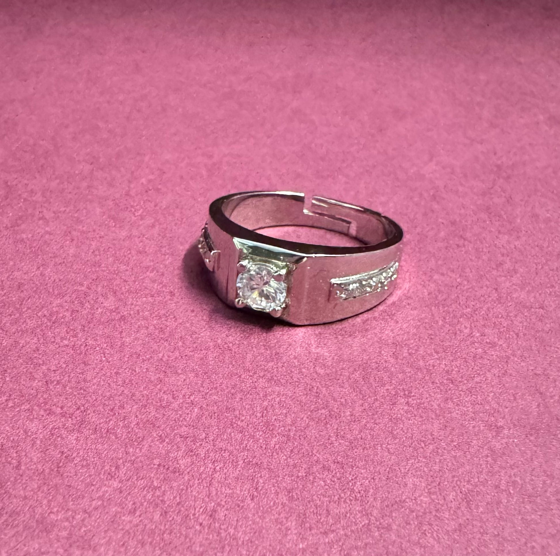 Silver ring with a diamond on a pink background