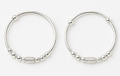 Pair of silver hoop earrings with bead detailing on a white background
