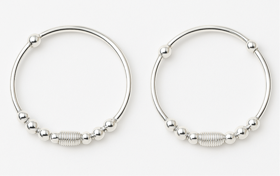 Pair of silver hoop earrings with bead detailing on a white background