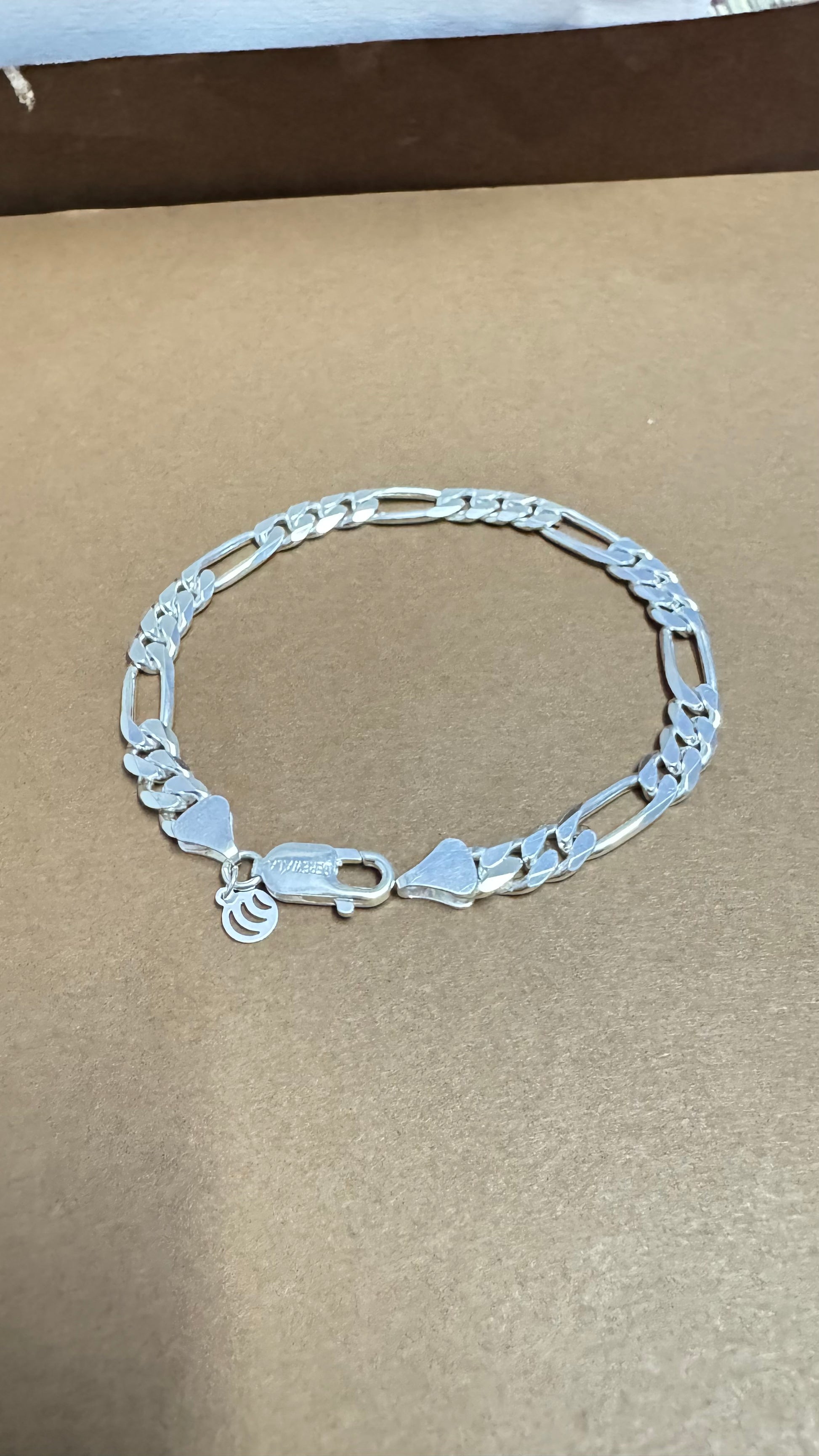 Silver bracelet on a brown background