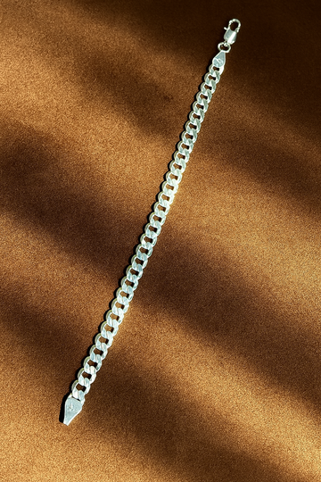 Silver chain bracelet on a brown fabric background