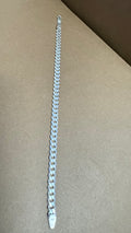 Silver chain bracelet on a beige surface