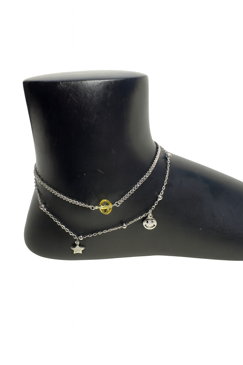 Sterling silver charm anklet with star, smiley, and heart pendants on yellow background