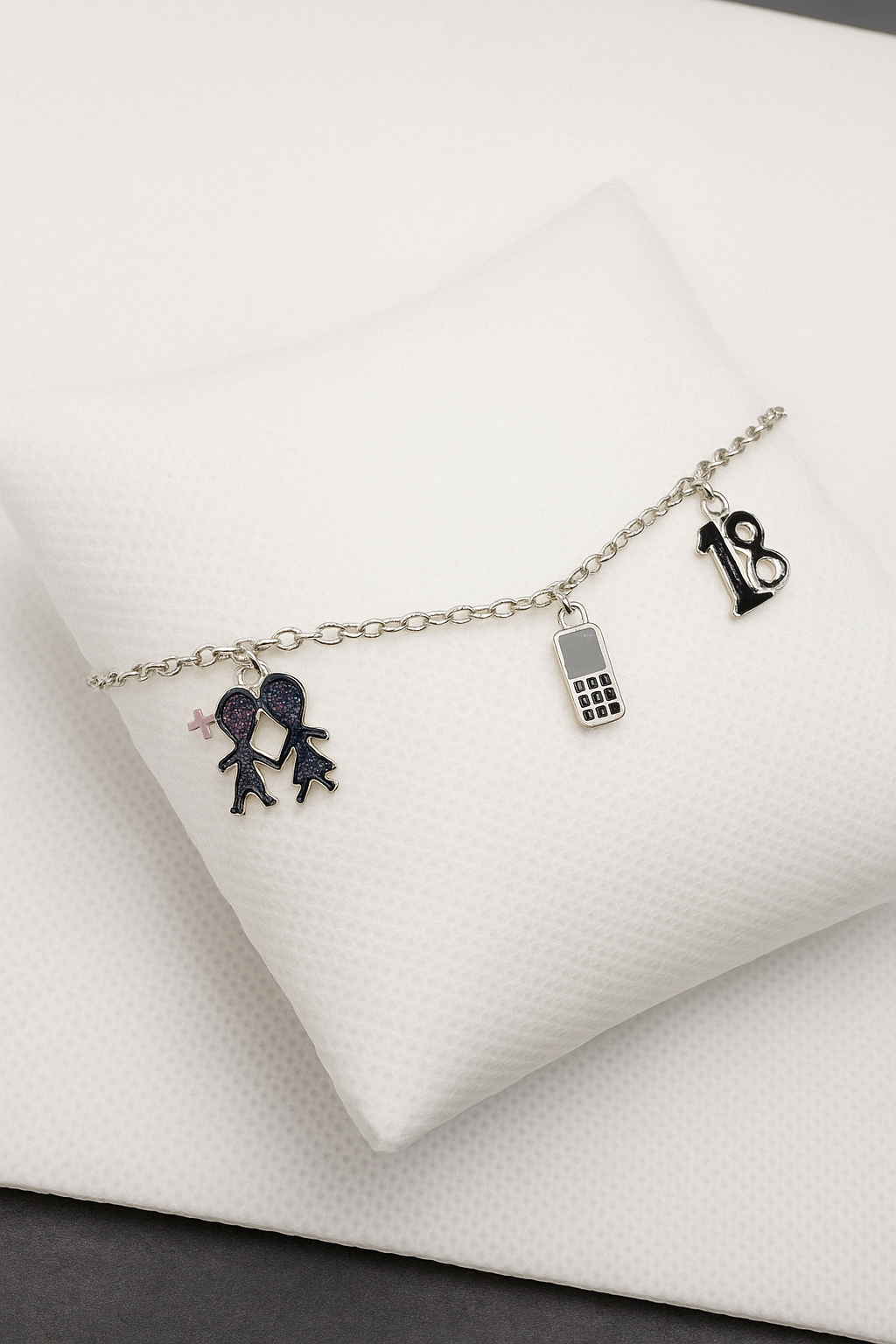 Bracelet with charms on a wrist against a neutral background