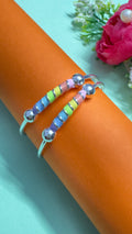 Colorful beaded bracelet on a wrist with a light blue and orange background