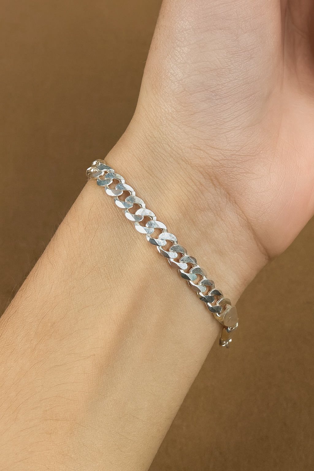 Silver chain bracelet on a brown fabric background