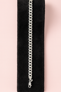 Silver chain bracelet on a black stand with a pink background