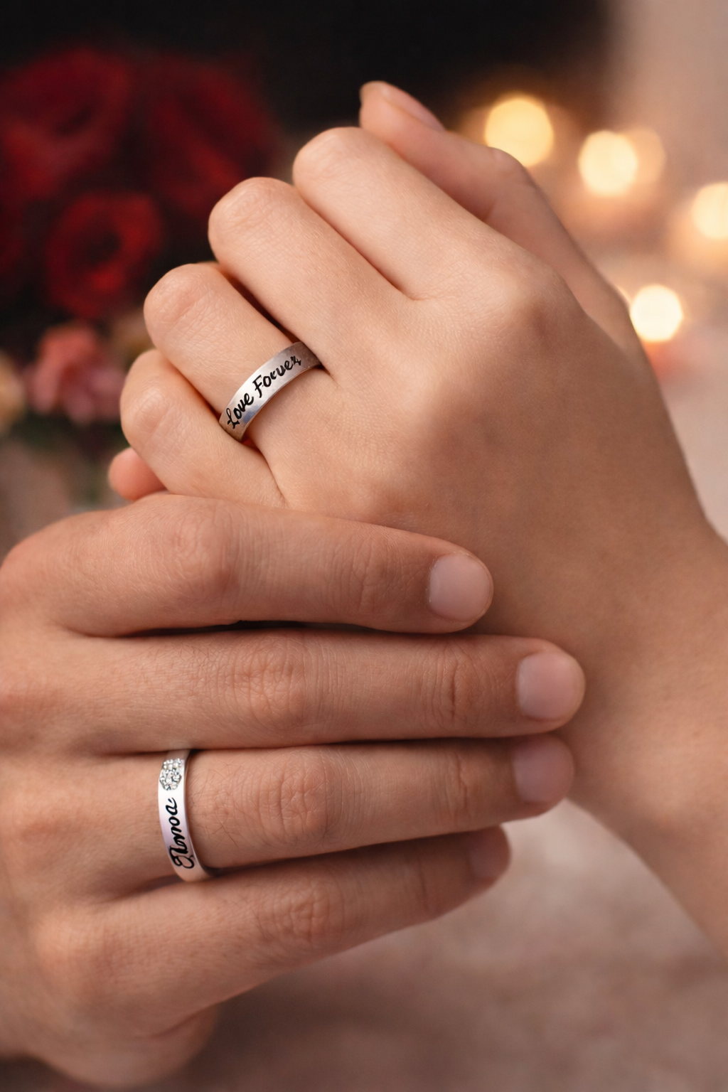Two silver rings with 'Forever Love' engraving on a red background with heart shapes.