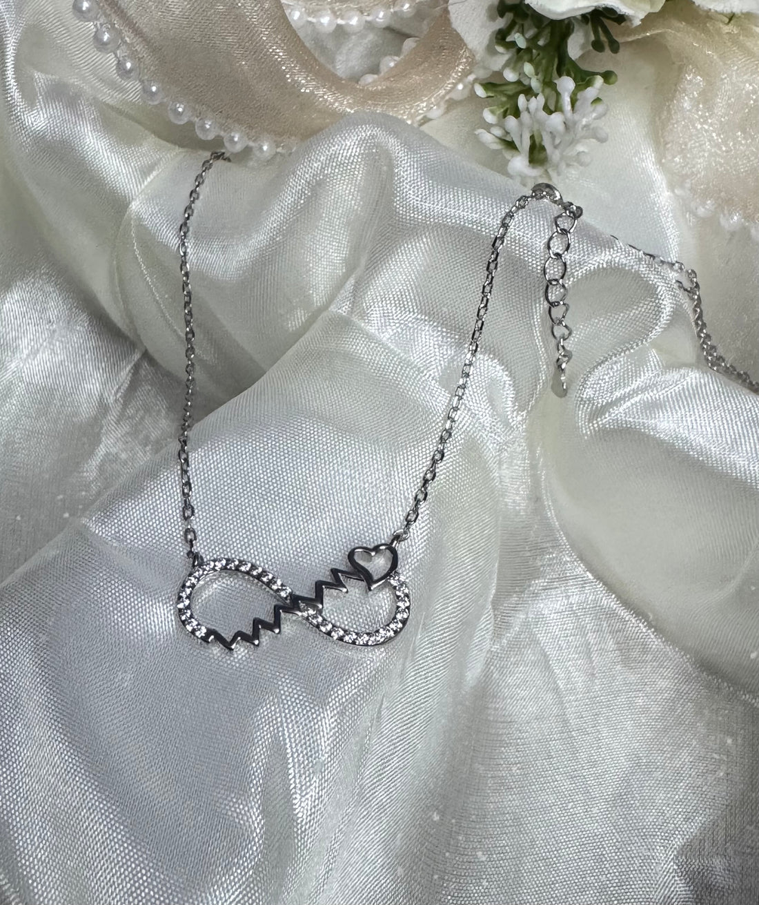 Silver necklace with a unique pendant on a black surface