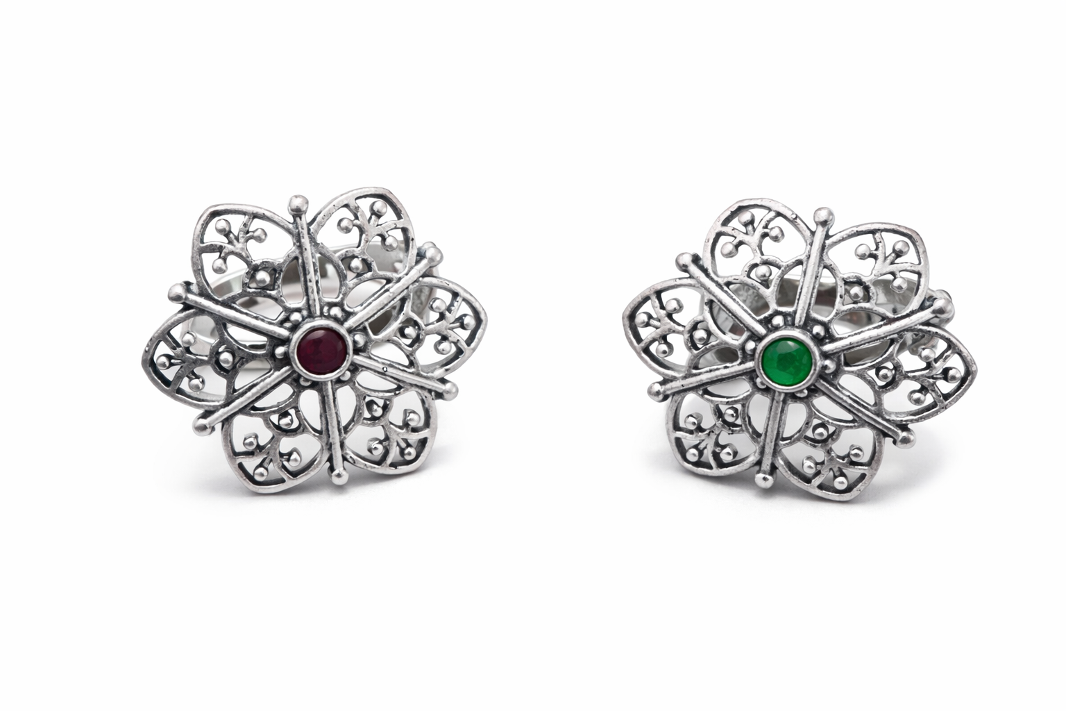 Pair of silver flower-shaped earrings with gemstones on a white background