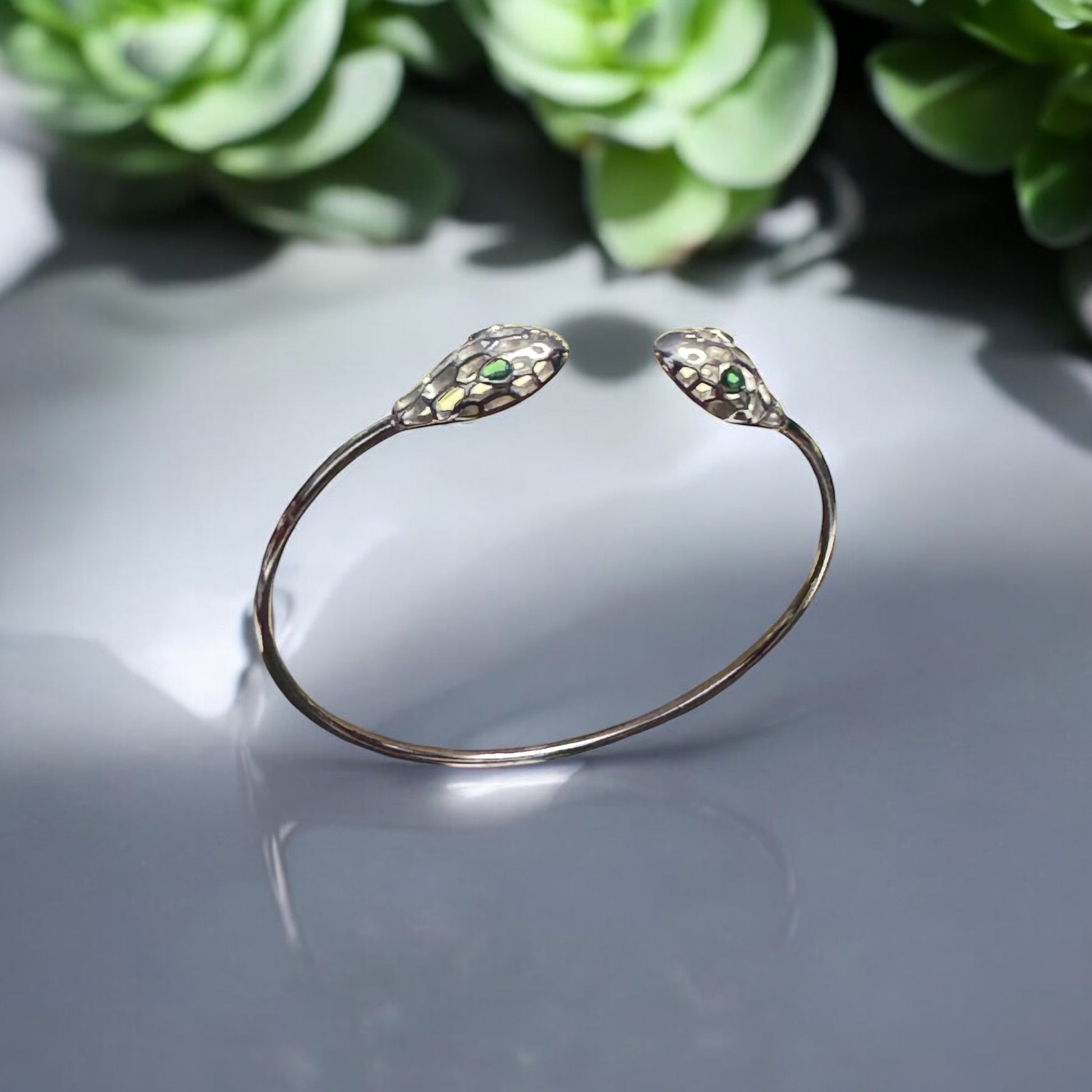 Adjustable sterling silver cuff bracelet with green gemstone snake heads