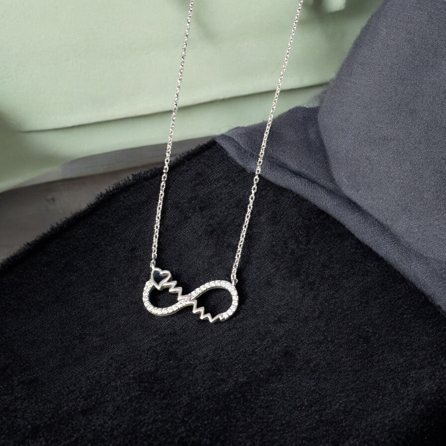 Silver necklace with a unique pendant on a black surface