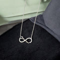 Silver necklace with a unique pendant on a black surface