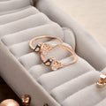 Rose gold ring with floral design on a soft gray surface
