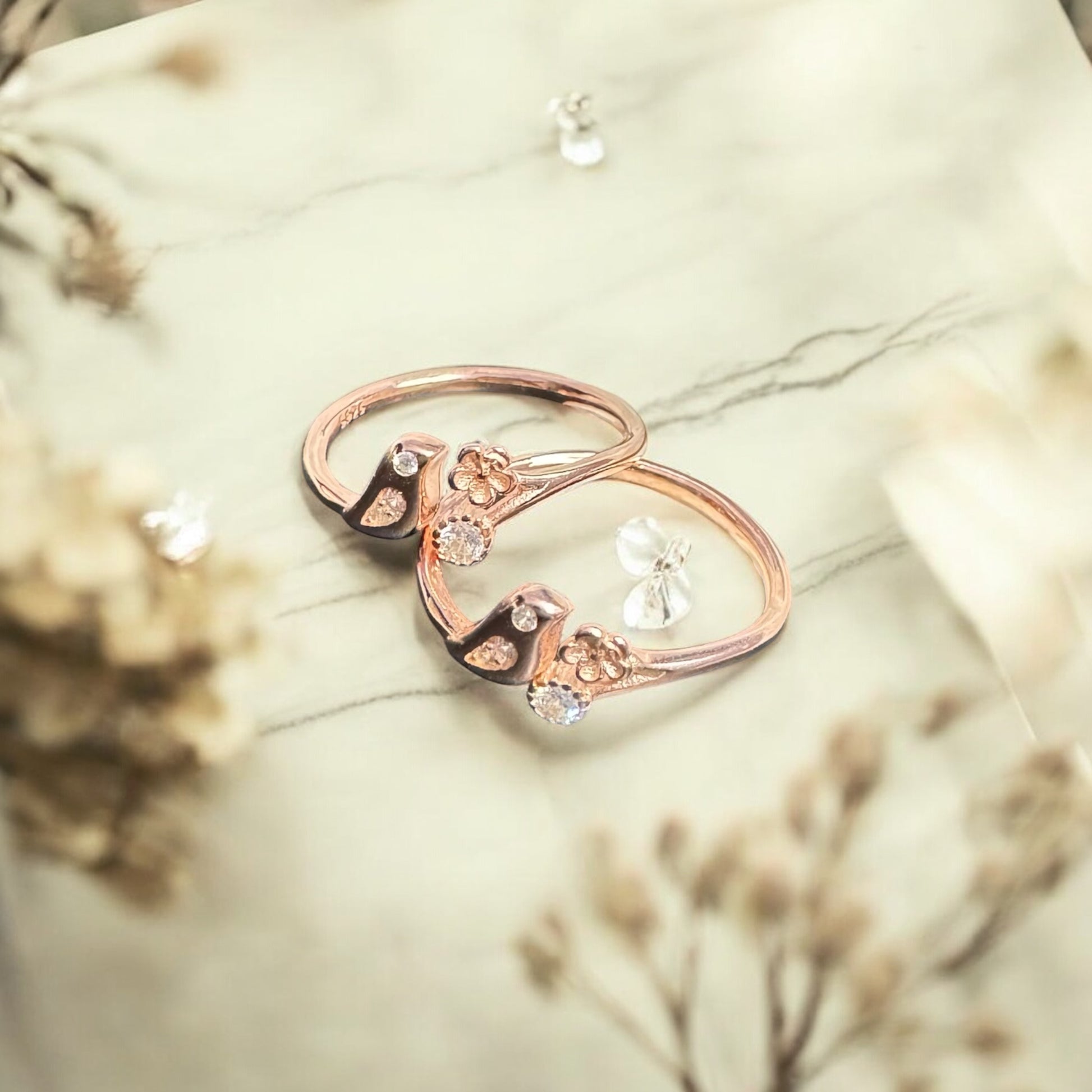 Rose gold ring with diamonds on a marble surface