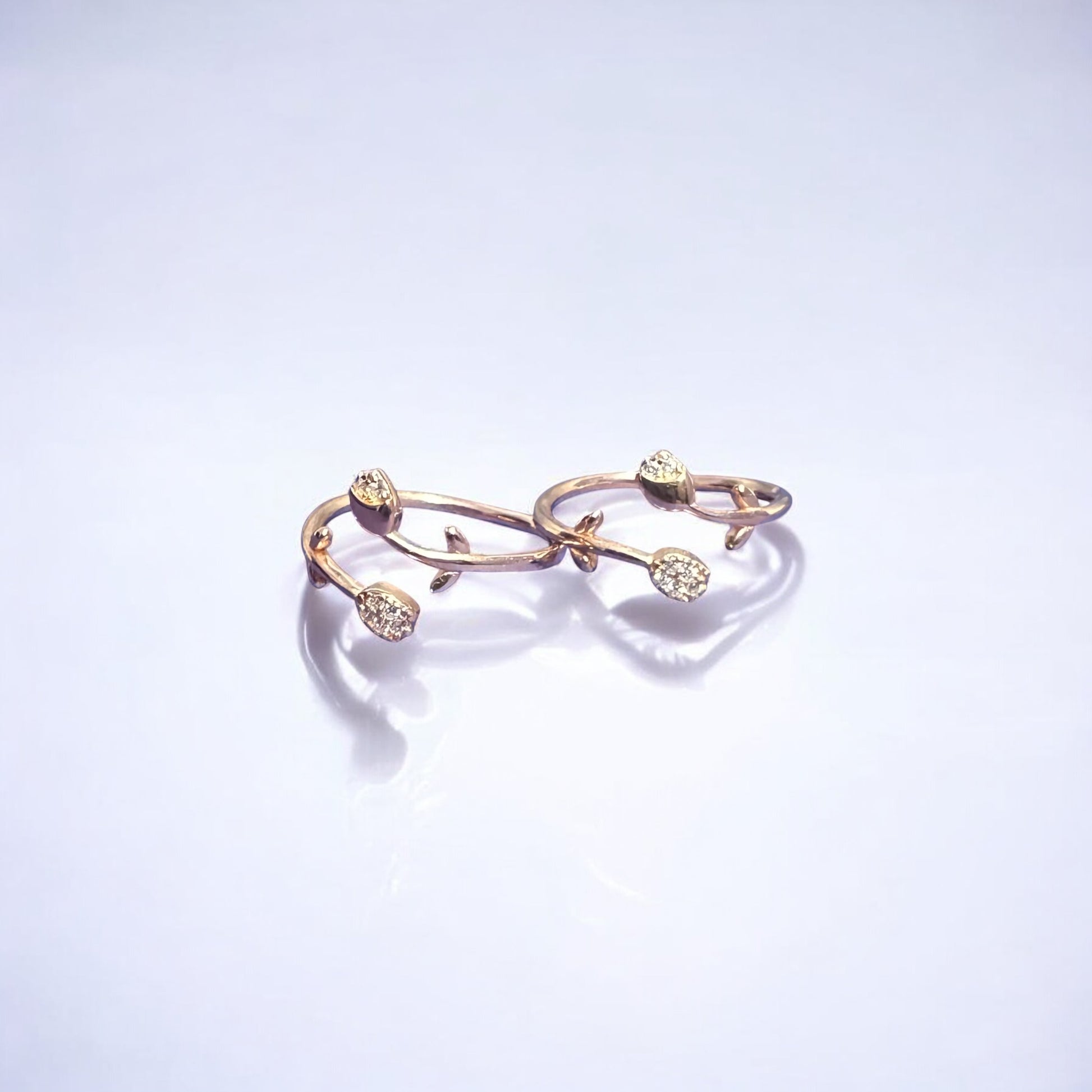 Gold ring with floral design on a light purple background