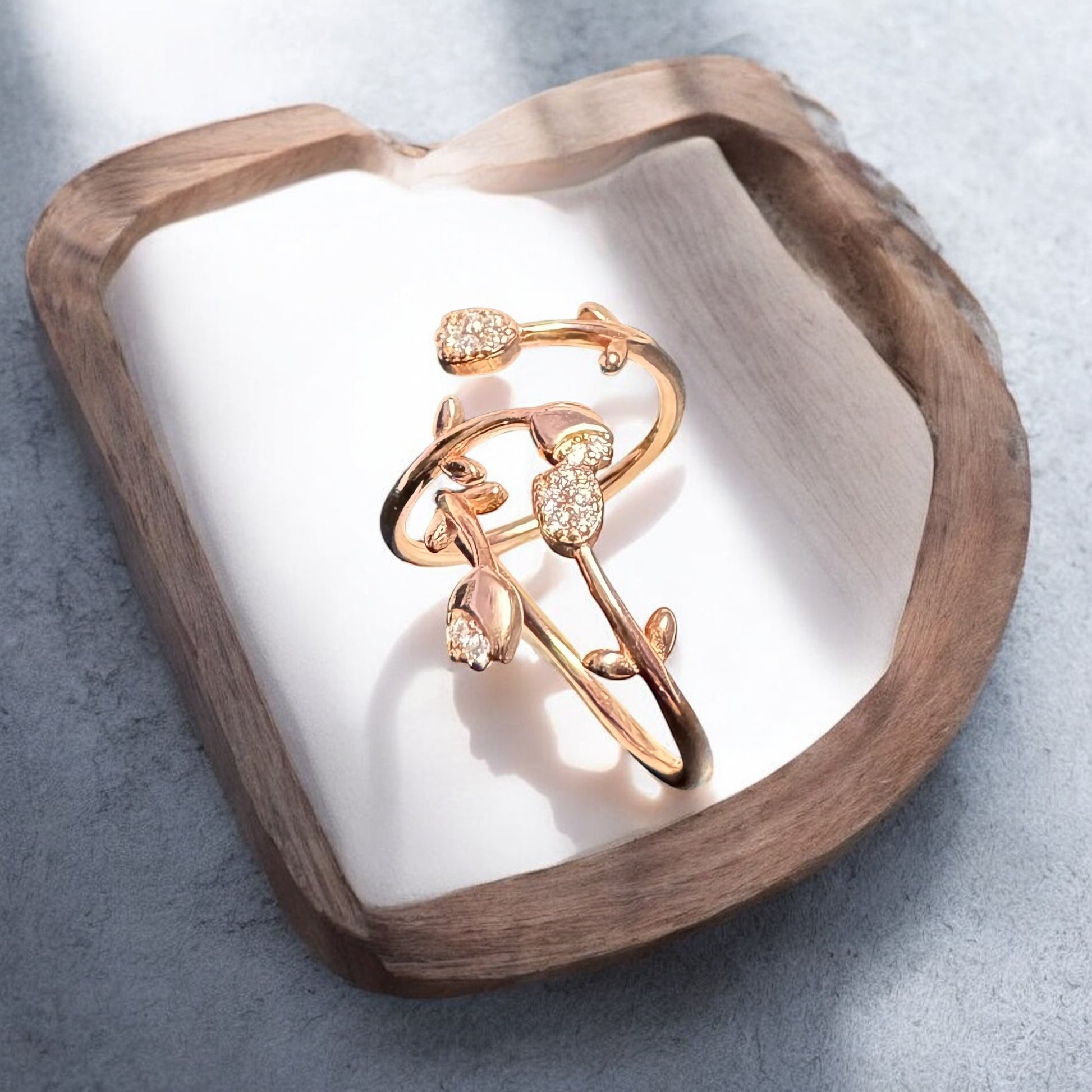 Rose gold ring with diamonds on a heart-shaped wooden stand