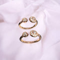 Set of three rose gold rings with gemstones on a light pink fabric background