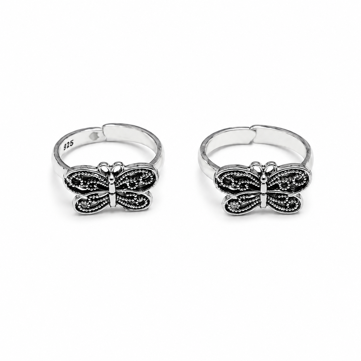 Two butterfly-shaped silver rings on a white background