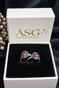Two silver rings with oval pink gemstones displayed in an open white ASG Silver House gift box with a black velvet insert.