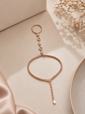 Rose gold bracelet on a beige surface with dried flowers
