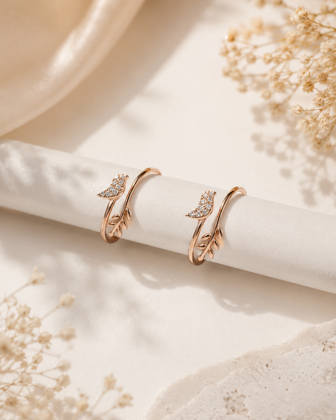 Rose gold bird toe ring pair on white background