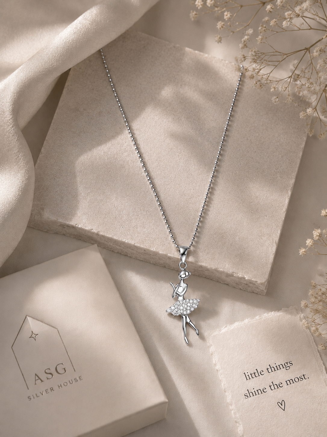 Silver necklace with a fairy pendant on a soft beige background