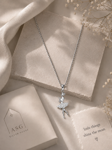 Silver necklace with a fairy pendant on a soft beige background
