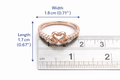 Rose gold ring with heart design on a ruler for size reference