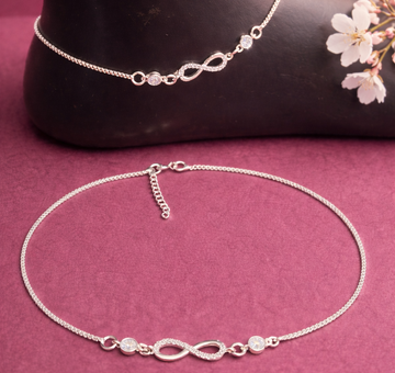 Silver anklets with infinity symbol on a pink surface with flowers