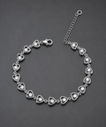 Silver bracelet with heart-shaped links on a dark gray background