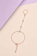 Rose gold bracelet with small stones on a beige and purple background