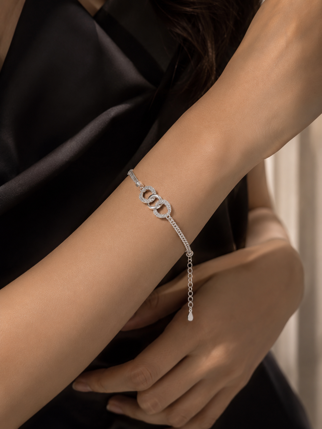 Silver bracelet on a person's wrist with a dark background