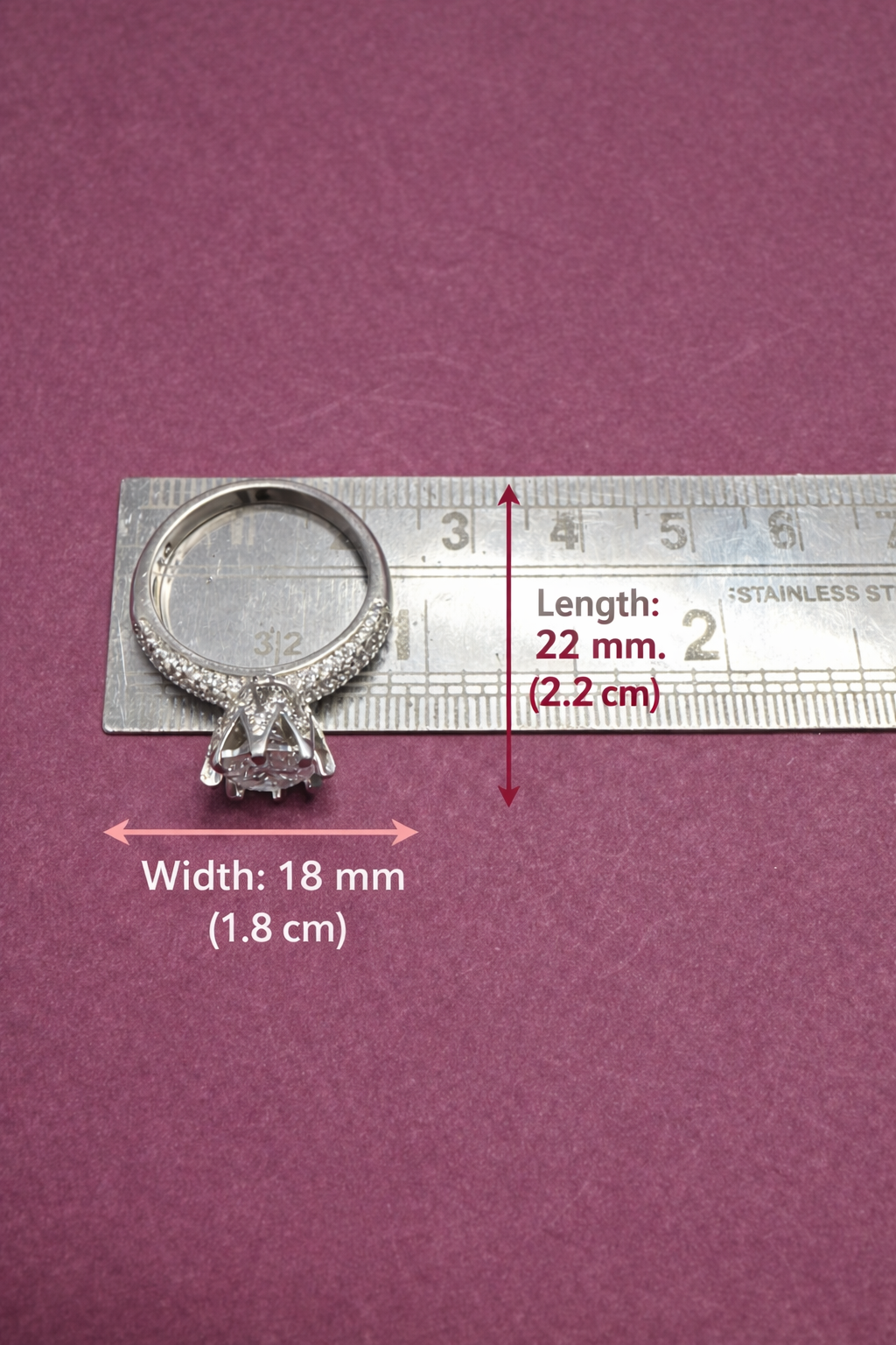 Silver ring with measurements on a purple background