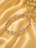 Delicate bracelet with small crystals on a gold fabric background