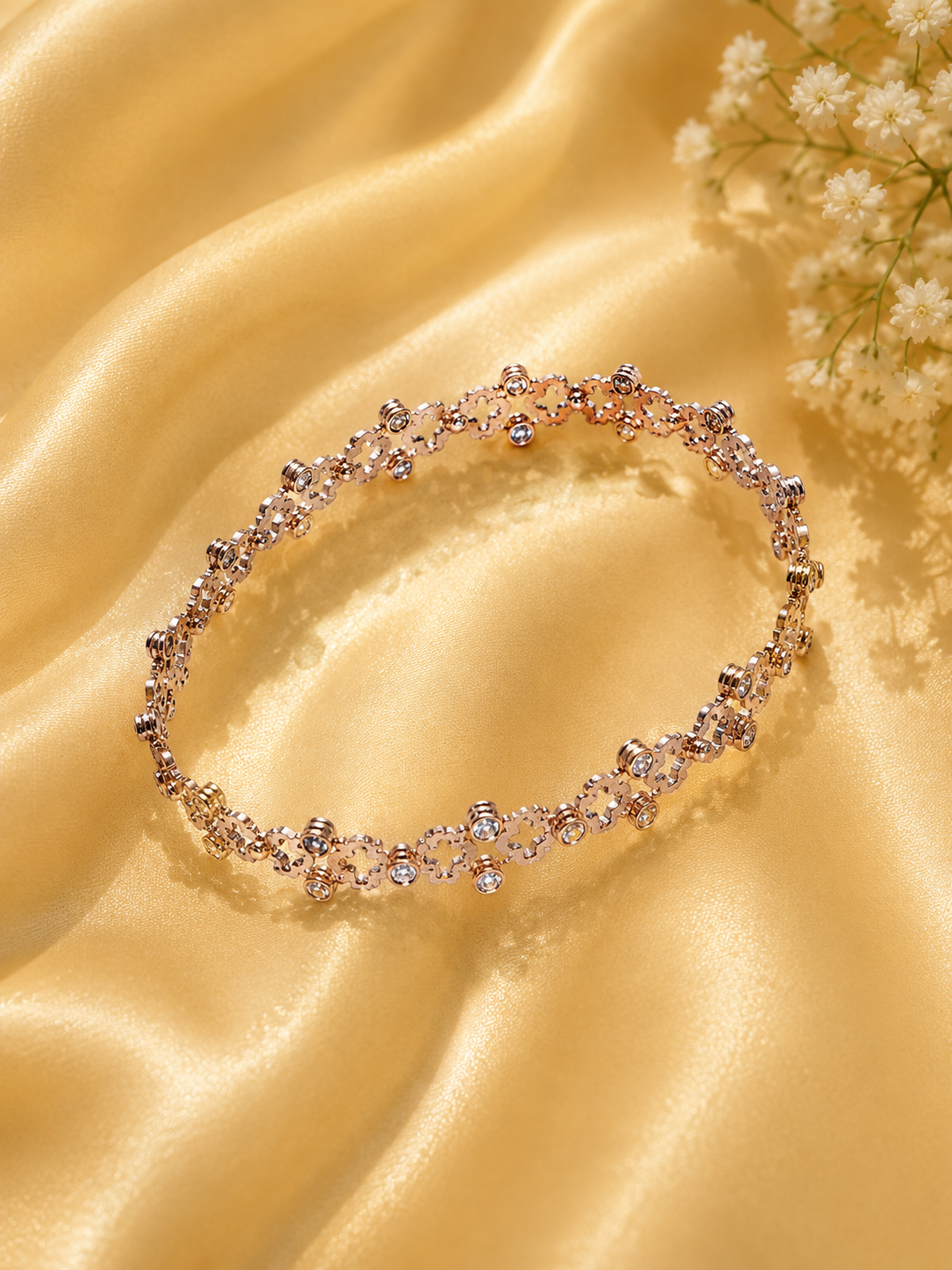 Delicate bracelet with small crystals on a gold fabric background