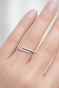 Silver ring with a small diamond on a hand against a light background