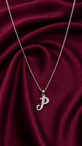 Silver necklace with a 'P' pendant on a burgundy fabric background
